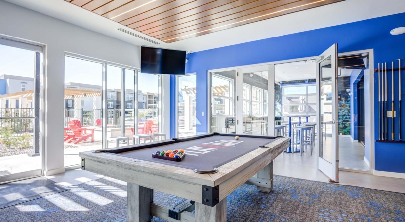 a pool table in a room with windows